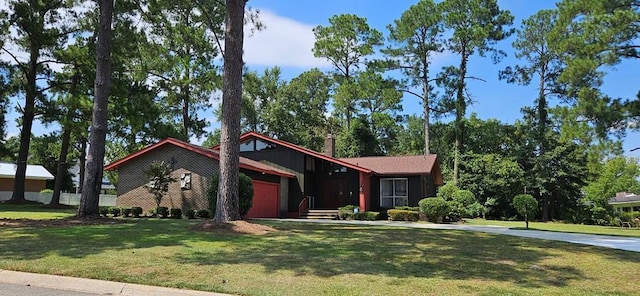 single story home featuring a garage and a front lawn