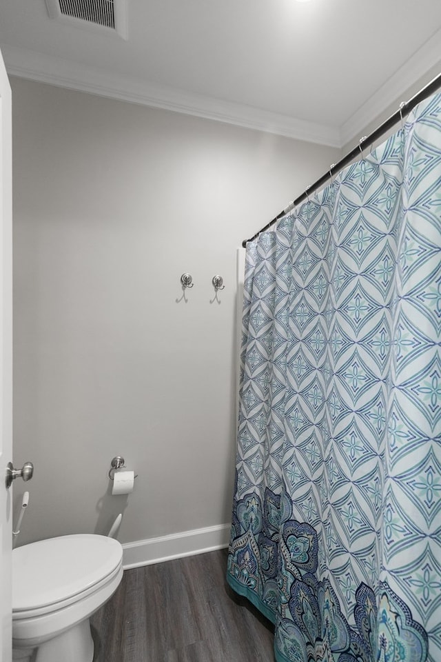 318 Oconee Dr, Midland City, AL 36350 - bathroom with crown molding, wood finished floors, toilet, baseboards, and a shower with curtain