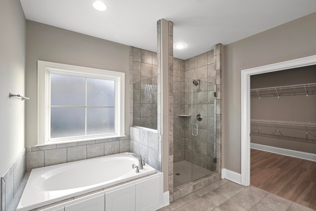 bathroom featuring shower with separate bathtub