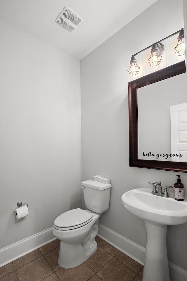 bathroom featuring sink, toilet, and tile patterned flooring