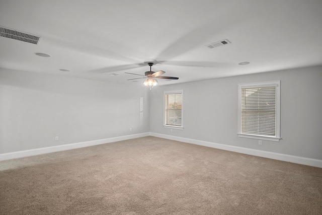 carpeted spare room featuring ceiling fan