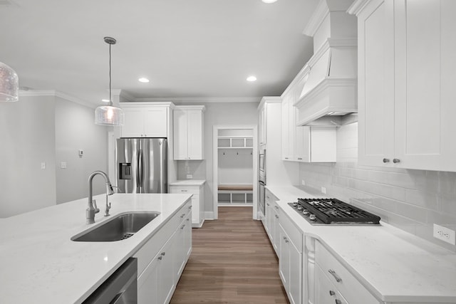 kitchen with pendant lighting, sink, white cabinetry, stainless steel appliances, and light stone counters