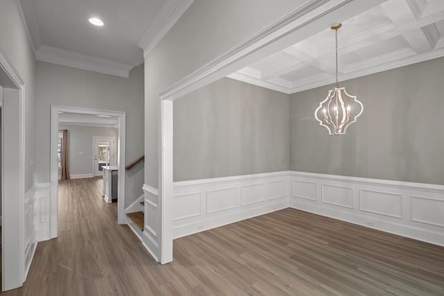 unfurnished dining area featuring coffered ceiling, hardwood / wood-style floors, beam ceiling, and a notable chandelier