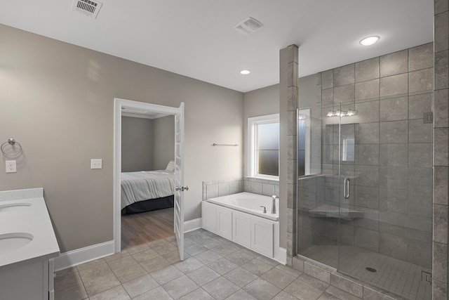 bathroom featuring vanity, independent shower and bath, and tile patterned flooring