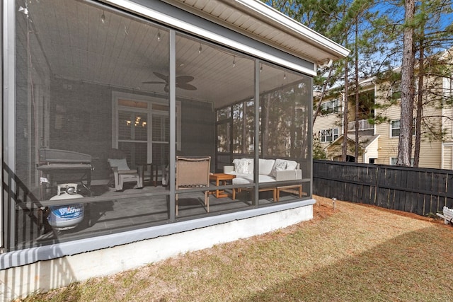 wooden deck featuring ceiling fan, a yard, and a sunroom