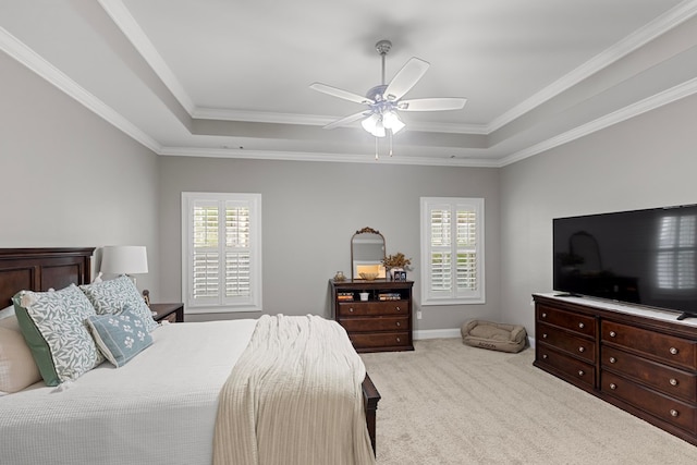 bedroom featuring a raised ceiling, ceiling fan, and multiple windows