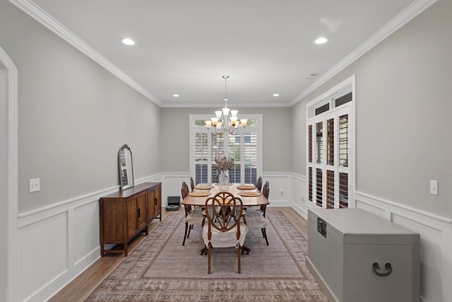 dining area featuring an inviting chandelier, light wood-type flooring, and crown molding