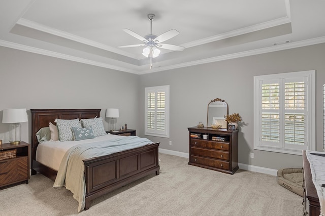 bedroom with multiple windows, ceiling fan, and a tray ceiling