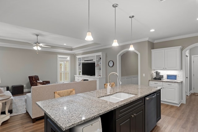 kitchen featuring dishwasher, a kitchen island with sink, ceiling fan, sink, and white cabinetry