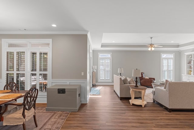 living room with ceiling fan, crown molding, dark hardwood / wood-style floors, and a tray ceiling