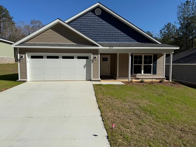 view of front facade with a porch, a garage, and a front lawn