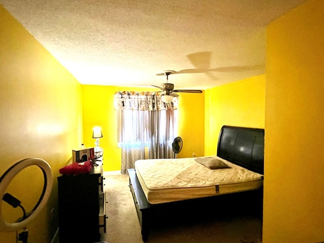 carpeted bedroom with a ceiling fan, a textured ceiling, and baseboards