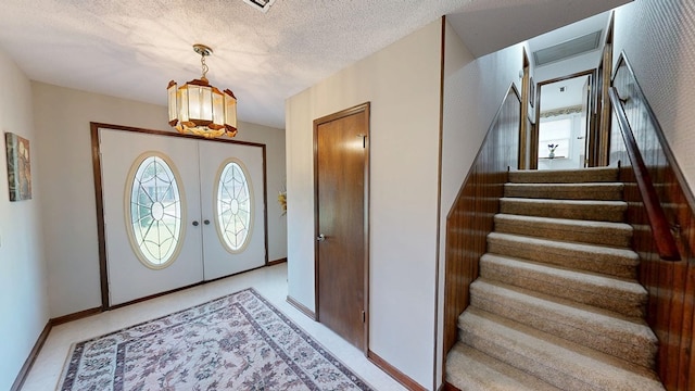 2104 Centenial Dr, Dothan, AL 36303 - entryway featuring stairs, a chandelier, french doors, and a textured ceiling