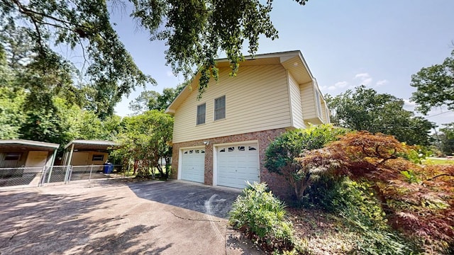 2104 Centenial Dr, Dothan, AL 36303 - view of side of home with driveway, an attached garage, a carport, and brick siding