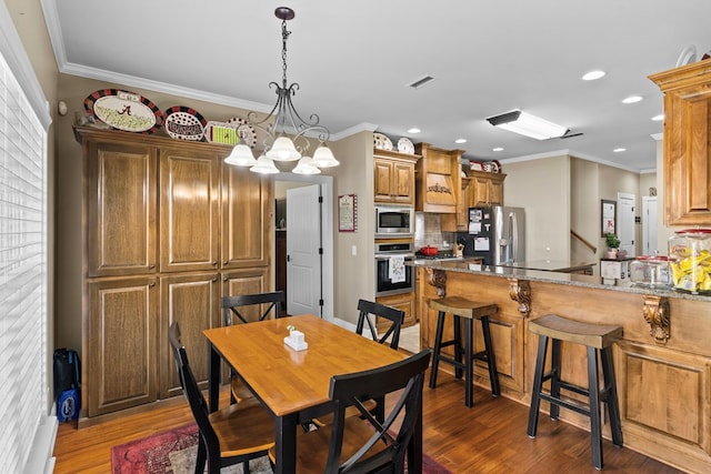 dining room with ornamental molding, an inviting chandelier, and dark wood-type flooring