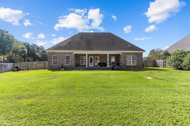 rear view of house featuring a lawn and a patio