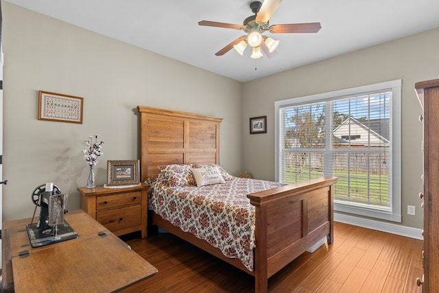 bedroom featuring hardwood / wood-style floors, ceiling fan, and multiple windows