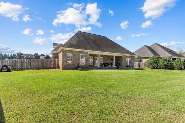 rear view of property featuring a yard and a patio