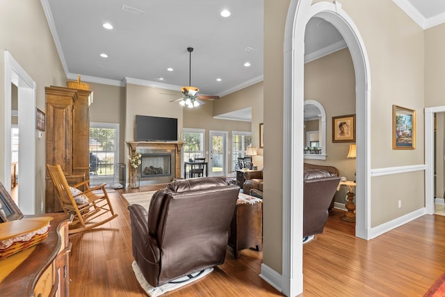 living room with light hardwood / wood-style flooring, ceiling fan, and ornamental molding