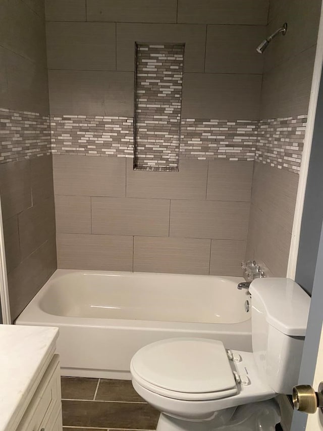 full bathroom featuring tile patterned floors, vanity, toilet, and tiled shower / bath