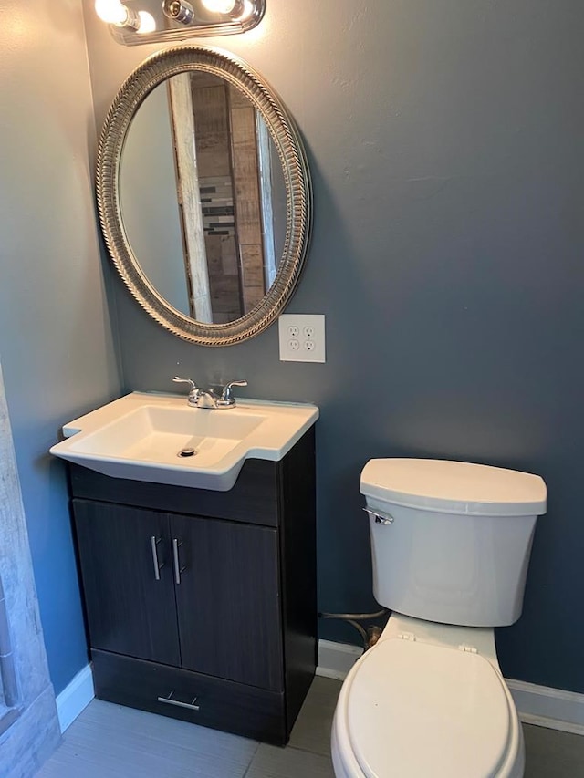 bathroom with tile patterned flooring, vanity, and toilet