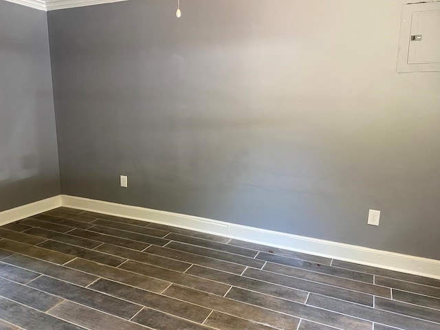 empty room with electric panel, crown molding, and dark hardwood / wood-style floors