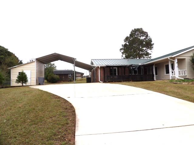 view of front of home with a front lawn and a carport