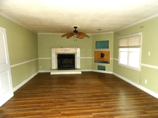 unfurnished living room featuring dark hardwood / wood-style floors, ceiling fan, and crown molding