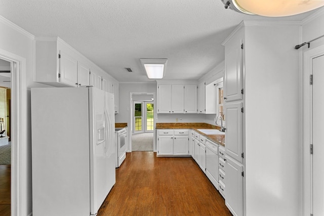 1104 Strathmore Ave, Dothan, AL 36303 - kitchen featuring white appliances, dark wood-type flooring, white cabinets, a textured ceiling, and light countertops