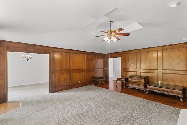 1104 Strathmore Ave, Dothan, AL 36303 - unfurnished living room featuring lofted ceiling, a ceiling fan, wood finished floors, a chandelier, and wooden walls