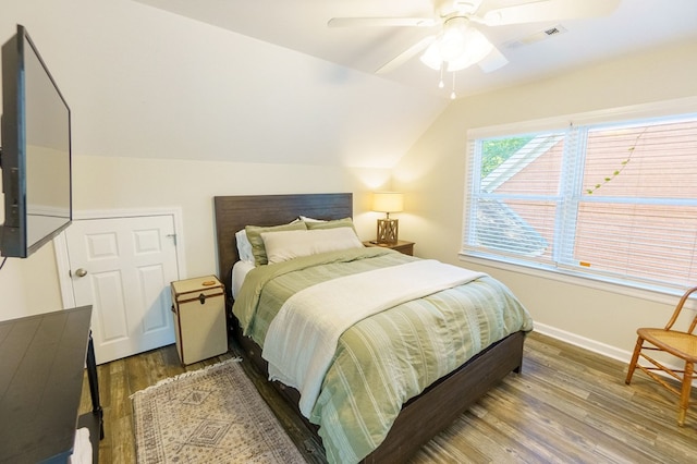 bedroom with hardwood / wood-style flooring, vaulted ceiling, and ceiling fan