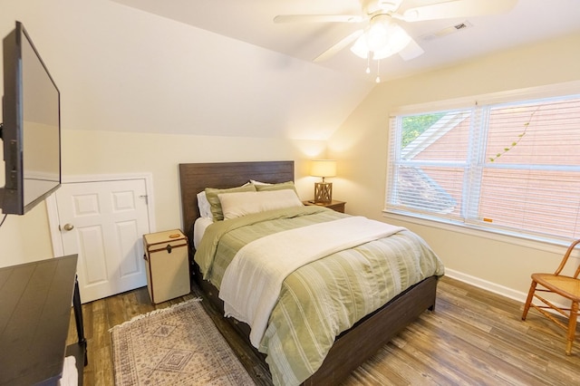 bedroom with ceiling fan, dark hardwood / wood-style flooring, and vaulted ceiling