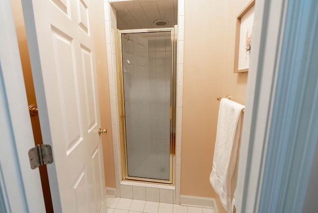 bathroom with tile patterned floors and a shower with door