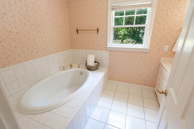 bathroom with tile patterned floors, a relaxing tiled tub, and vanity