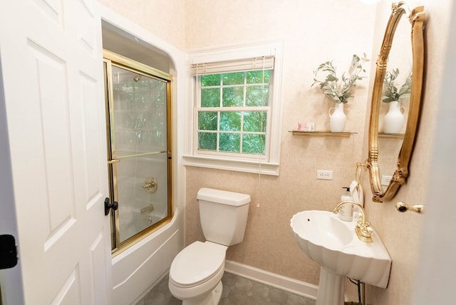 bathroom with combined bath / shower with glass door, tile patterned floors, and toilet