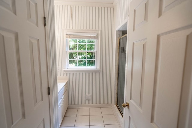 bathroom featuring tile patterned flooring, vanity, and a shower with door