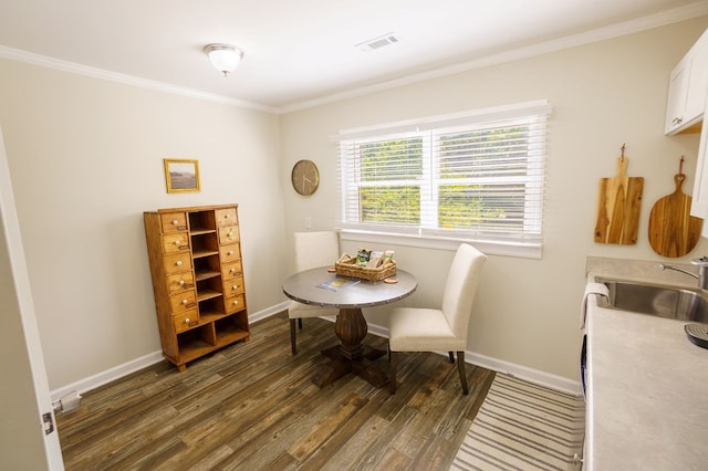 dining room with dark hardwood / wood-style floors, ornamental molding, and sink