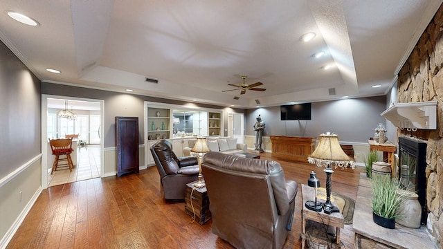 103 Yorkshire St, Dothan, AL 36305 - living room featuring a tray ceiling, a stone fireplace, wood-type flooring, a ceiling fan, and crown molding