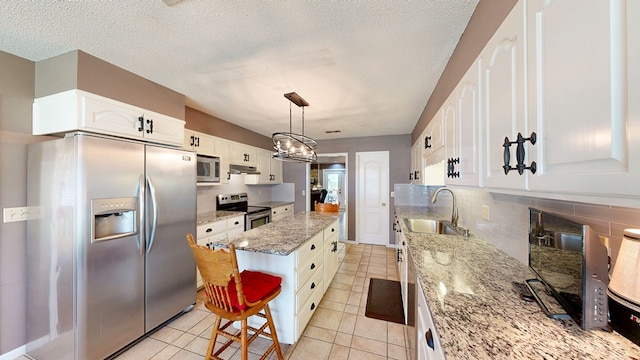103 Yorkshire St, Dothan, AL 36305 - kitchen featuring stainless steel appliances, a center island, tasteful backsplash, light stone countertops, and white cabinets