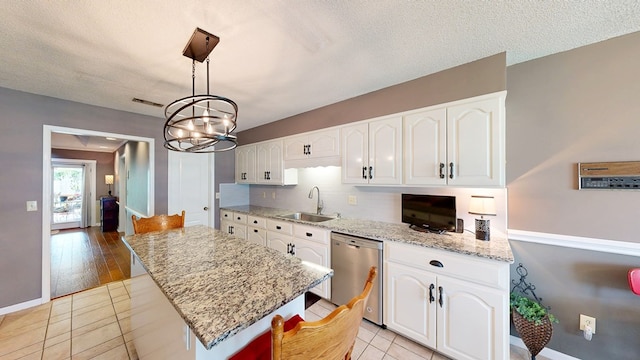 103 Yorkshire St, Dothan, AL 36305 - kitchen with stainless steel dishwasher, white cabinetry, a chandelier, light stone counters, and a kitchen island