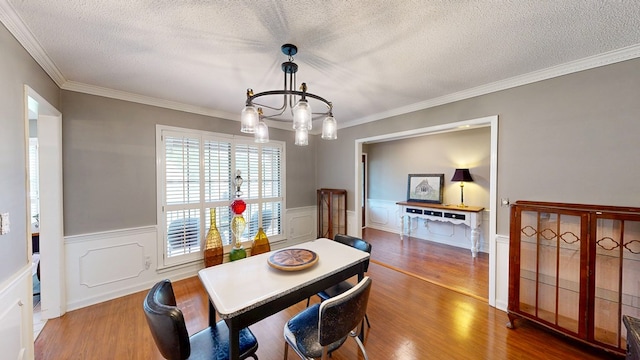 103 Yorkshire St, Dothan, AL 36305 - dining area featuring a chandelier, a textured ceiling, wood finished floors, wainscoting, and ornamental molding
