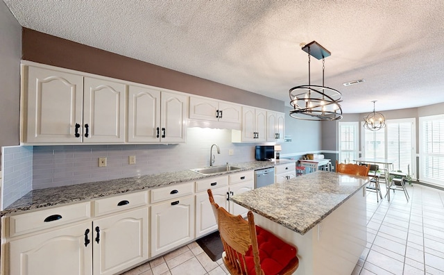 103 Yorkshire St, Dothan, AL 36305 - kitchen with stainless steel dishwasher, light tile patterned floors, a chandelier, a kitchen island, and backsplash