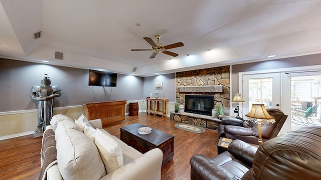 103 Yorkshire St, Dothan, AL 36305 - living room with a ceiling fan, wood finished floors, a stone fireplace, a raised ceiling, and wainscoting