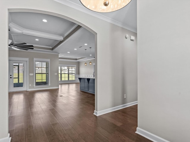 unfurnished living room with arched walkways, ornamental molding, baseboards, dark wood finished floors, and coffered ceiling