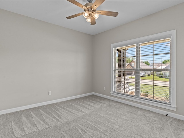 spare room with carpet, baseboards, and ceiling fan