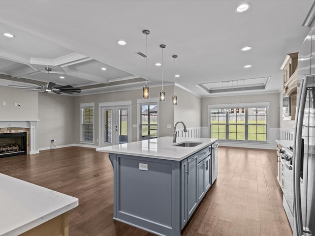 kitchen with a sink, open floor plan, a ceiling fan, a center island with sink, and dark wood-type flooring