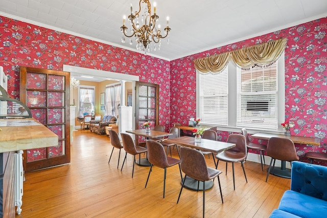 307 S Academy St, Geneva, AL 36340 - dining space with wallpapered walls, ornamental molding, a chandelier, and hardwood / wood-style flooring