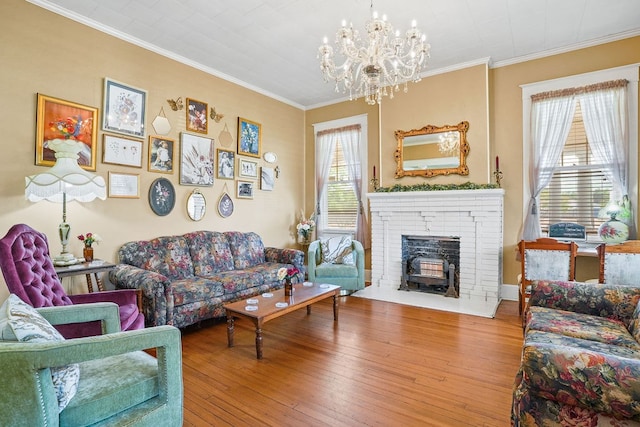 307 S Academy St, Geneva, AL 36340 - living room featuring a chandelier, ornamental molding, wood-type flooring, and a brick fireplace