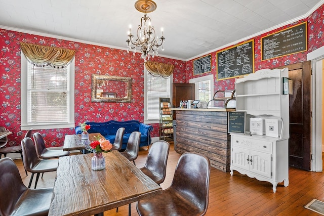 307 S Academy St, Geneva, AL 36340 - dining space featuring wallpapered walls, crown molding, a chandelier, and hardwood / wood-style floors