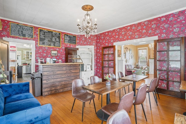 307 S Academy St, Geneva, AL 36340 - dining area with wallpapered walls, crown molding, hardwood / wood-style flooring, and a chandelier